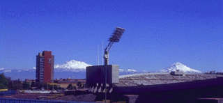 El Estadio Olímpico Universitario (derecha), La Torre de Rectoría (izquierda), al fondo los volcanes Iztaccíhuatl (izquierda) y Popocatépetl (derecha).