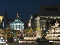 Vista nocturna del lado occidental de la plaza, con la fuente en primer término, el Edificio Metrópolis en la parte central izquierda y la sede del Banco Santander Central Hispano a la derecha. La imagen corresponde a la Navidad de 2007.