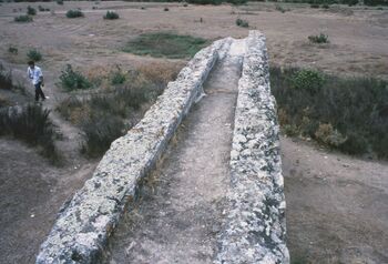 Fragmento de canal del acueducto de Itálica, Santiponce (Sevilla). En la parte más lejana se aprecia el revestimiento de opus signinum y la protección de las intersecciones.
