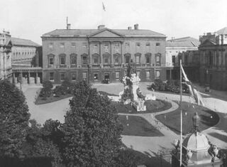 Leinster House en 1911, decorada para la visita del Rey Jorge V La estatua de la Reina Victoria en el patio fue removida en 1947