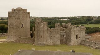 Parte del Castillo Pembroke. La fortaleza grande de la izquierda se construyó en el 1200 AD, su altura es de 23 metros (75 pies) y las murallas en su base son de 6 metros (19 pies) de grosor.