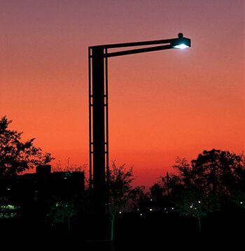 Lámpara de haluro metálico en un poste del alumbrado público, se le puede apreciar el tono del color emitido por la lámpara